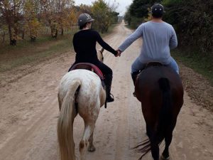couple riding a horse and holding hands at estancia in Argentina